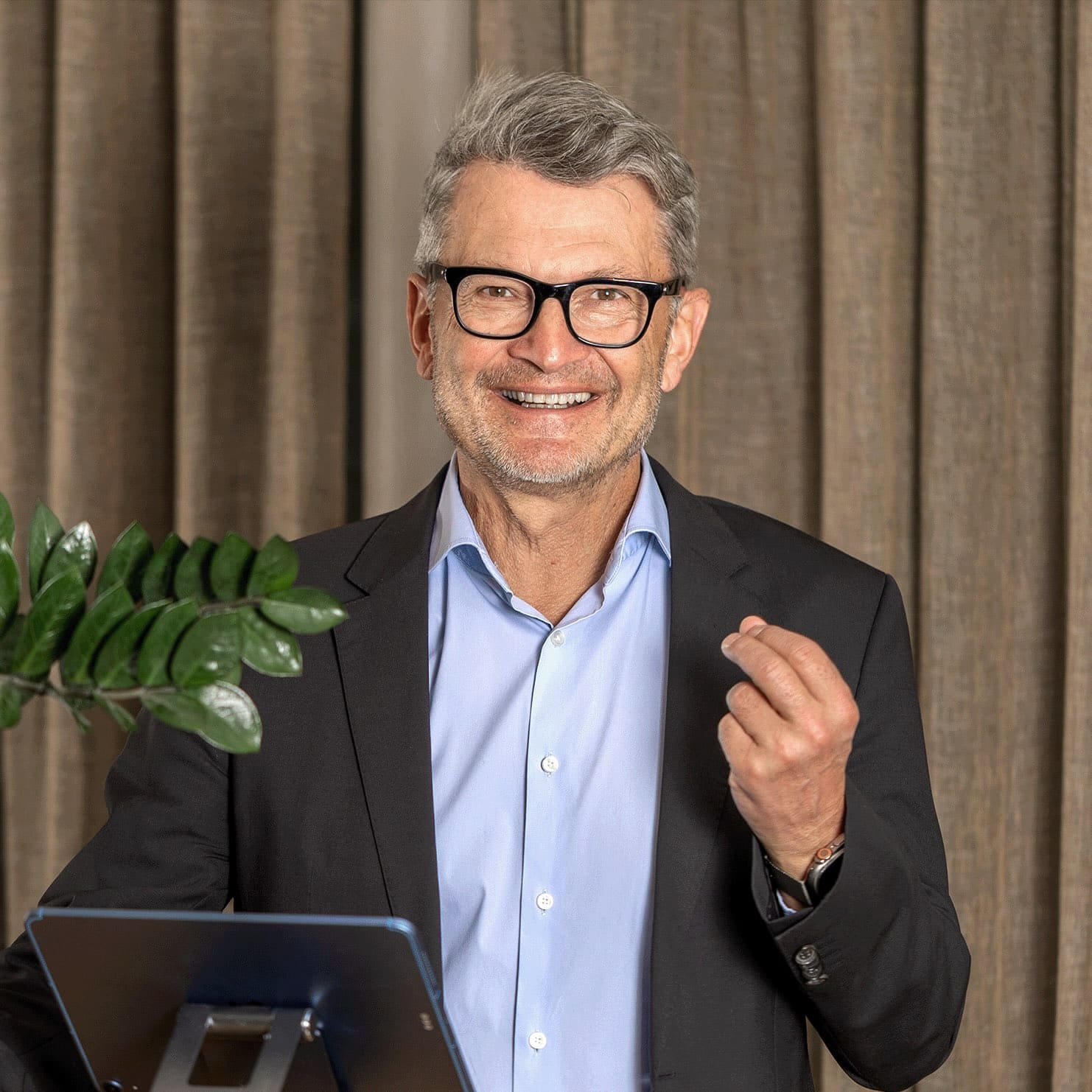 Thomas Wachter steht vor einem Vorhang und spricht, Kontakt- und Beratungssituation.